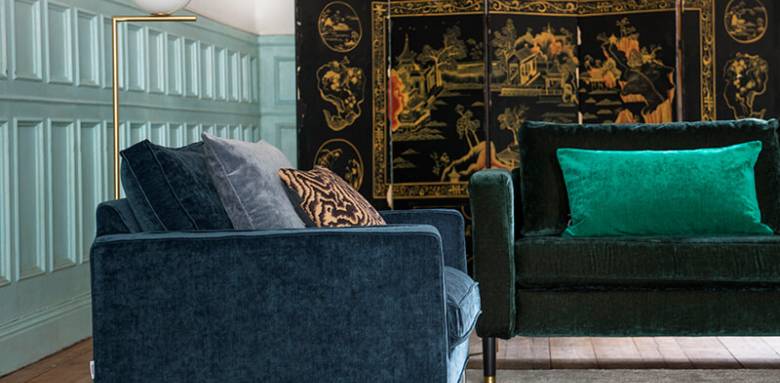 Canapé velours bleu nuit et coussin émeraude dans un salon