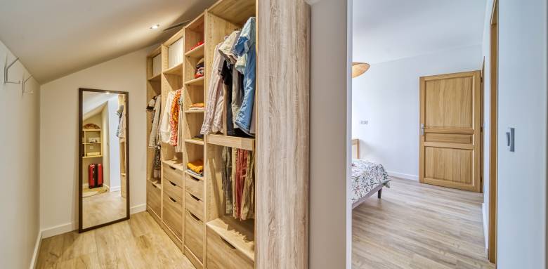 Astucieux, le coin dressing dans la sous-pente, derrière le lit