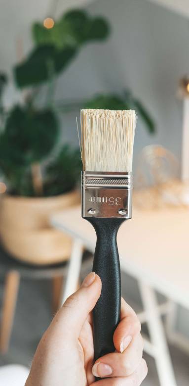 Une main tenant un pinceau 