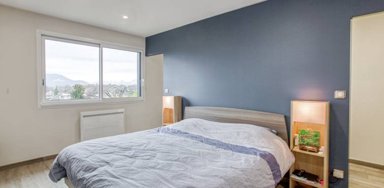 La large fenêtre apporte luminosité dans la chambre