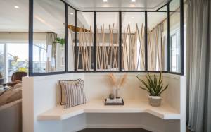 Un espace transformé : cette entrée rénovée allie esthétique et fonctionnalité,créant une transition harmonieuse entre l'extérieur et le salon grace à des matériaux modernes et une décoration soignée.
