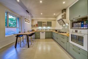 une cuisine bien éclairée : Des spots dans le plafond et un éclairage spécifique au-dessus de plan de travail, de la plaque de cuisson et de l'évier