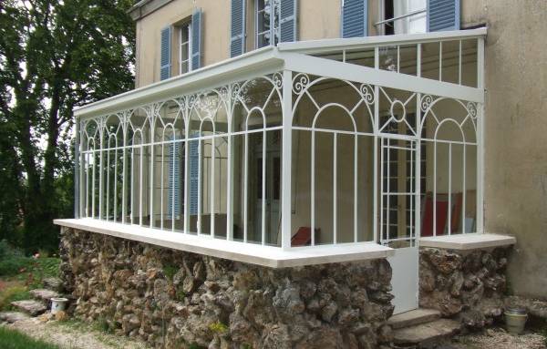 Véranda en fer forgé avec soubassement maçonné