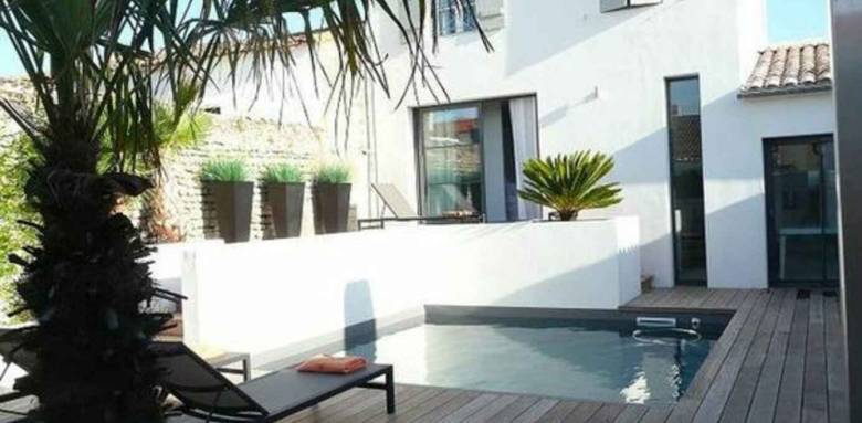 Petite piscine coque carrée mise en œuvre dans une cour intérieure à Bois-Plage