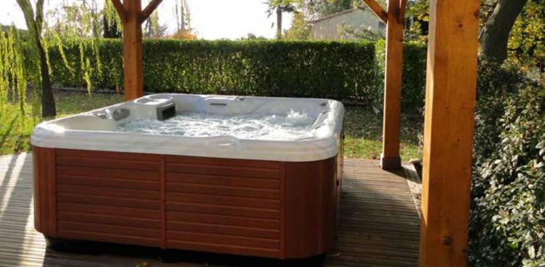 Spa à poser, sous un abris en bois, pour en profiter par tous les temps ! Modèle DESJOYAUX