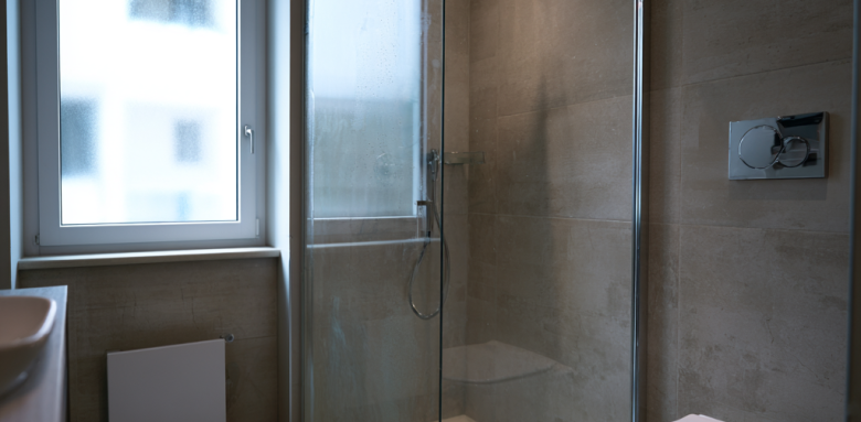 Salle de bain moderne avec douche vitrée et WC suspendu