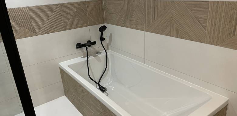 Une baignoire habillée avec de la faïence imitation bois