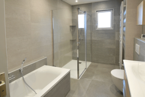 salle de bain rénovée avec baignoire et douche