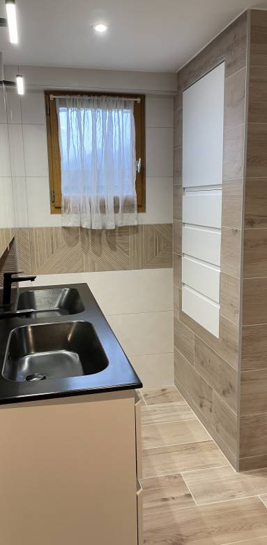 carrelage imitation bois au sol et sur les murs de cette salle de bain