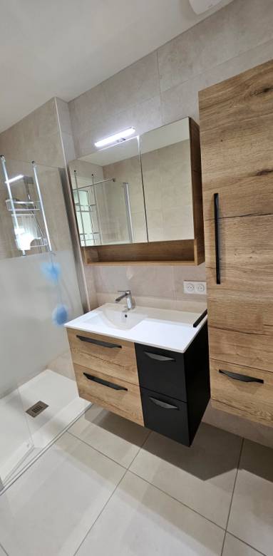 Intégration d'un receveur extra plat XXL dans salle de bain rénovée e nappartement avec meuble vasque adjacent