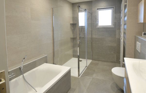 salle de bain rénovée avec baignoire et douche