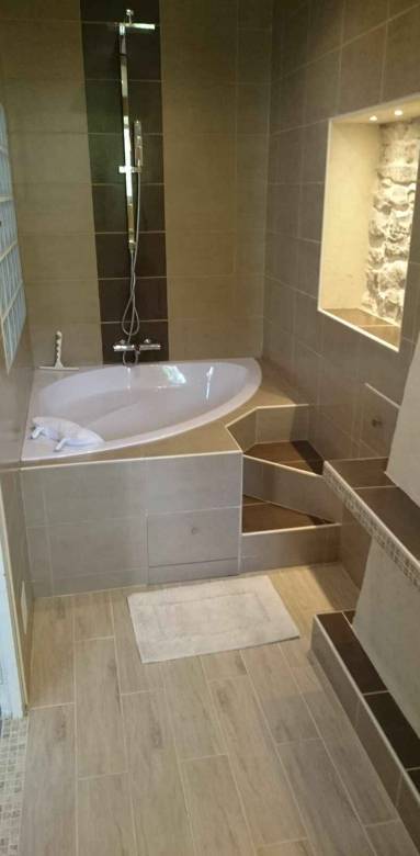 Petite salle de bain avec baignoire d'angle