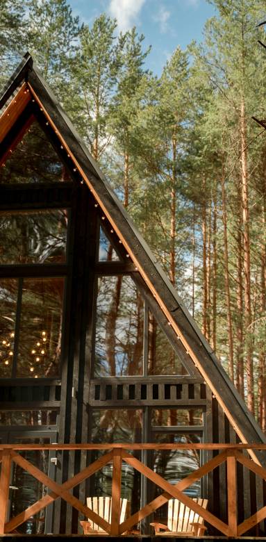 Maison en bois toute noire dans la forêt