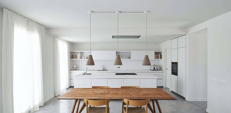 Une cuisine sur-mesure blanche et design avec coin repas en bois