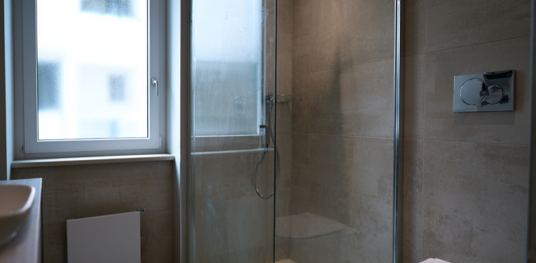 Salle de bain moderne avec douche vitrée et WC suspendu