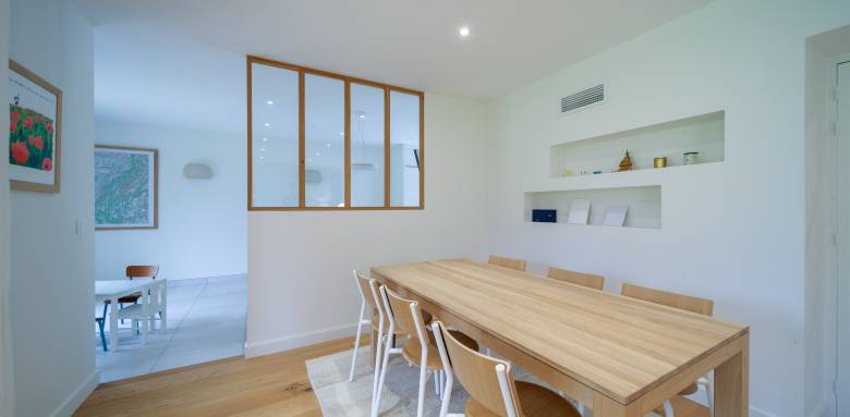 La chaleur du bois et la pureté du blanc dans cette salle à manger