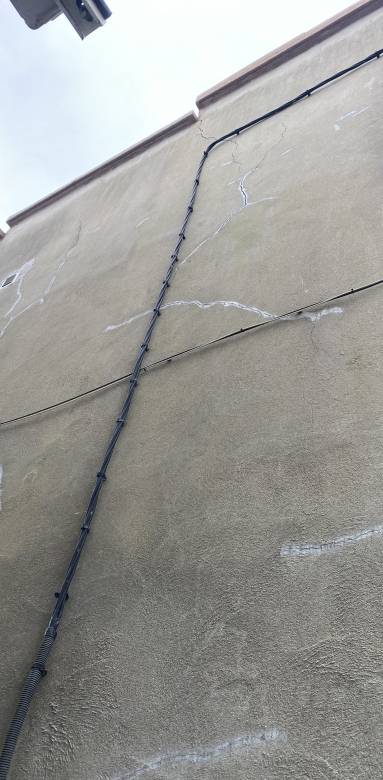 Nombreuses fissures sur pignon d'habitation 
