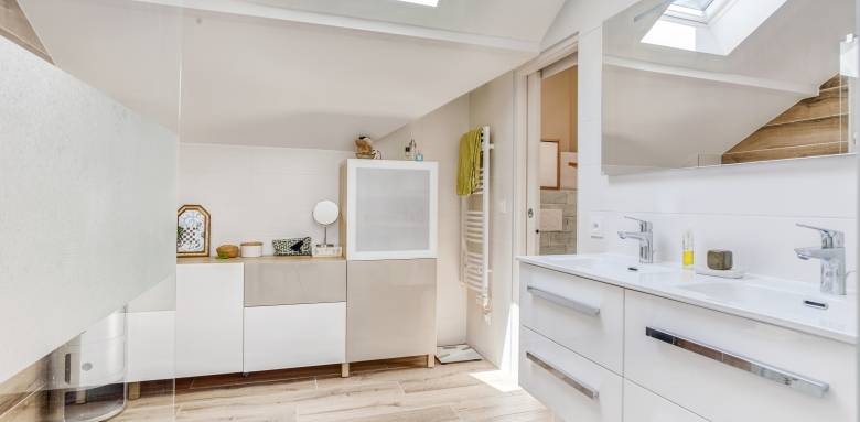 Une salle de bain chaleureuse grâce au sol en carrelage imitation bois