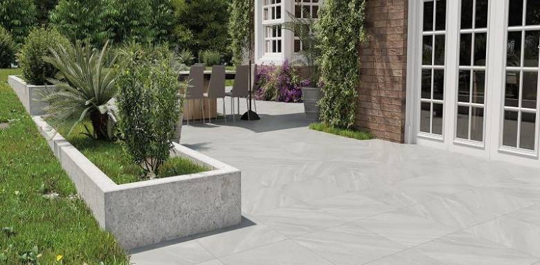 terrasse en carrelage extérieur grand format gris avec espace repas et jardin aménagé