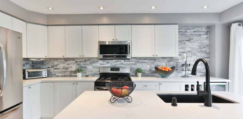 Une crédence en pierre dans une cuisine blanche et moderne 