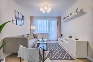 petit canapé, meuble bas et fonctionnel couleurs claires pour ce salon en longueur