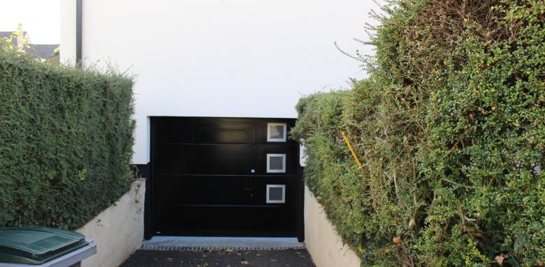 Porte de garage motorisée avec hublot en résidence 
