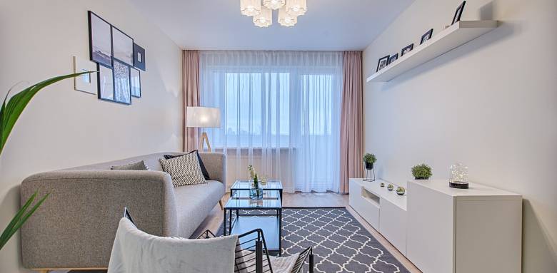 petit canapé, meuble bas et fonctionnel couleurs claires pour ce salon en longueur