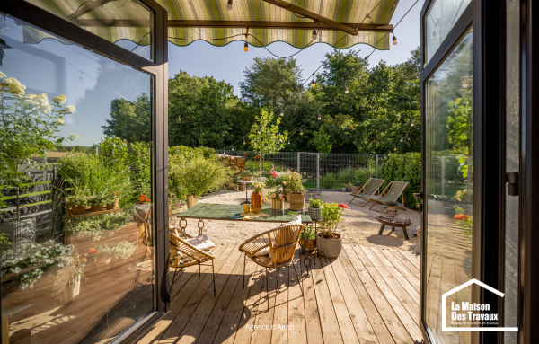 Terrasse en bois avec pergola et espace repas, exemple d’aménagement extérieur à Agen conçu pour profiter pleinement du jardin tout au long de l’été.