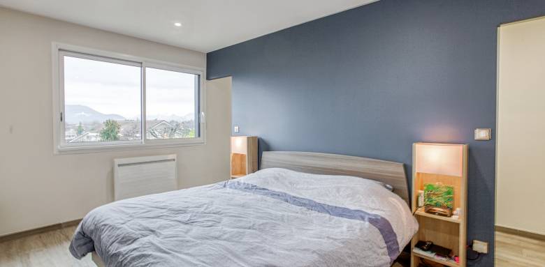 La large fenêtre apporte luminosité dans la chambre