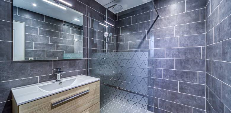 un éclairage led au dessus du miroir complète les spots encastrés