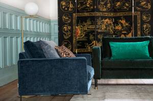 Canapé velours bleu nuit et coussin émeraude dans un salon