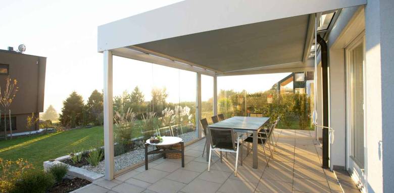 Coin repas dans un jardin sur une terrasse avec pergola 