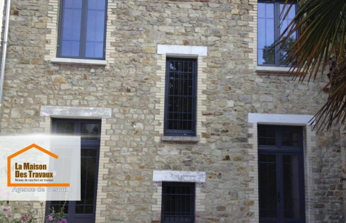 Façade en pierre rénovée à Saint-Loup-sur-Semouse : Pose de fenêtres en aluminium noir alliant charme et performance énergétique. Une rénovation élégante et durable.