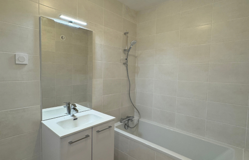 Salle de bains rénovée avec baignoire et meuble vasque