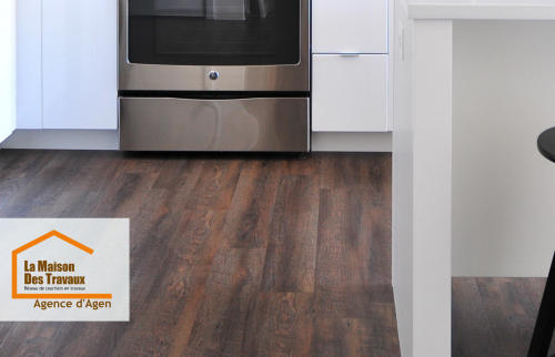 Un sol en parquet stratifié imitation bois foncé posé dans une cuisine moderne à Agen, par La Maison Des Travaux. Élégance et durabilité au rendez-vous.