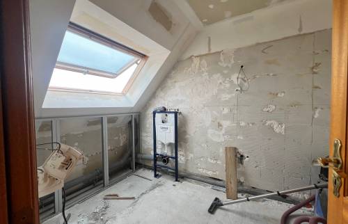 Début des travaux de rénovation d'une salle de bain avec murs déposés, bâti-support WC et préparation de plomberie.