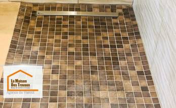 Détail du receveur de douche à l’italienne en mosaïque antidérapante, avec caniveau inox discret, réalisé par La Maison Des Travaux de Vesoul.