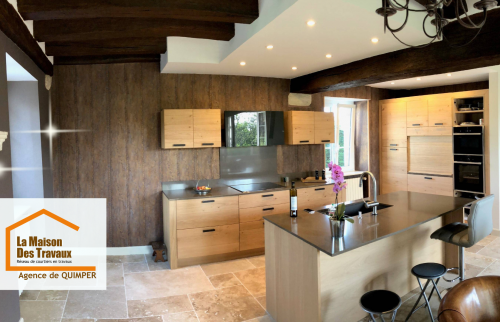 Rénovation complète d’une cuisine avec îlot central, éclairage encastré et finitions bois contemporain.