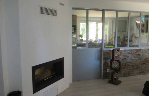 Cheminée double foyer et verrière atelier vu du salon à Rixheim