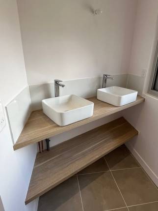 Meuble avec  vasques posées sur plan dans une salle de bain rénovée - Nantes 44