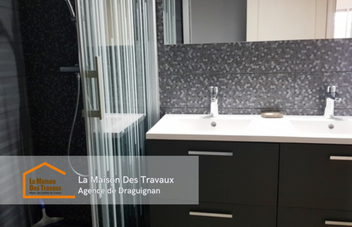 Vue de la douche moderne avec paroi en verre à rayures et robinetterie haut de gamme, pour un espace à la fois fonctionnel et esthétique.