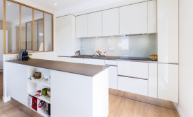 Aménagement cuisine avec espace repas central et verrière bois à 4 vitrages en délimitation plain-pied à Châteaulin (29150)