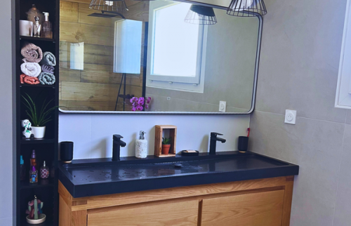 Meuble double vasque bois et plan noir mat dans une ambiance industrielle chic.