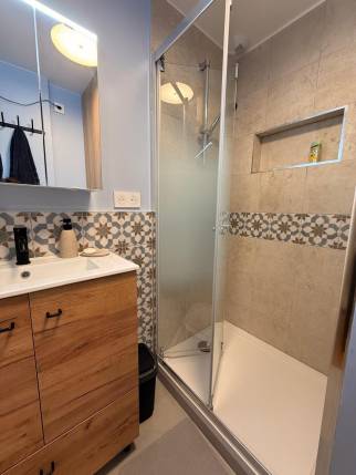 Cabine de douche en verre avec colonne pluie, rénovation Paris 18
