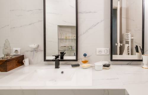 Vasque moderne avec robinet noir et miroir encadré, Paris 16e.