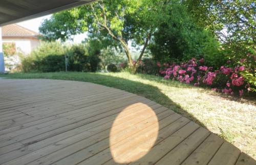 Les courbes de la terrasse s'intègrent harmonieusement au jardin pour un rendu élégant et naturel.