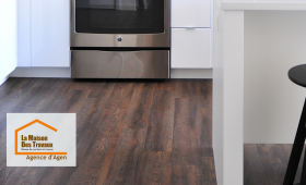 Un sol en parquet stratifié imitation bois foncé posé dans une cuisine moderne à Agen, par La Maison Des Travaux. Élégance et durabilité au rendez-vous.