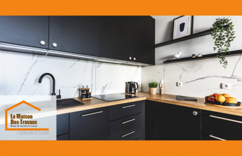 Cuisine rénovée à Agen : design moderne avec meubles noirs, bois clair et crédence marbre pour un espace fonctionnel et élégant.