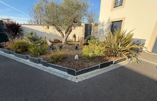 Aménagement d’une cour à Cabourg : enrobé drainant et massifs structurés