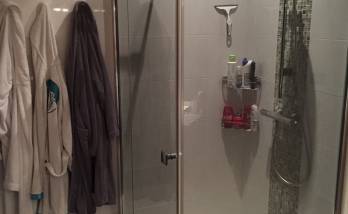 Cabine de douche avec sol en galet et faïence murale